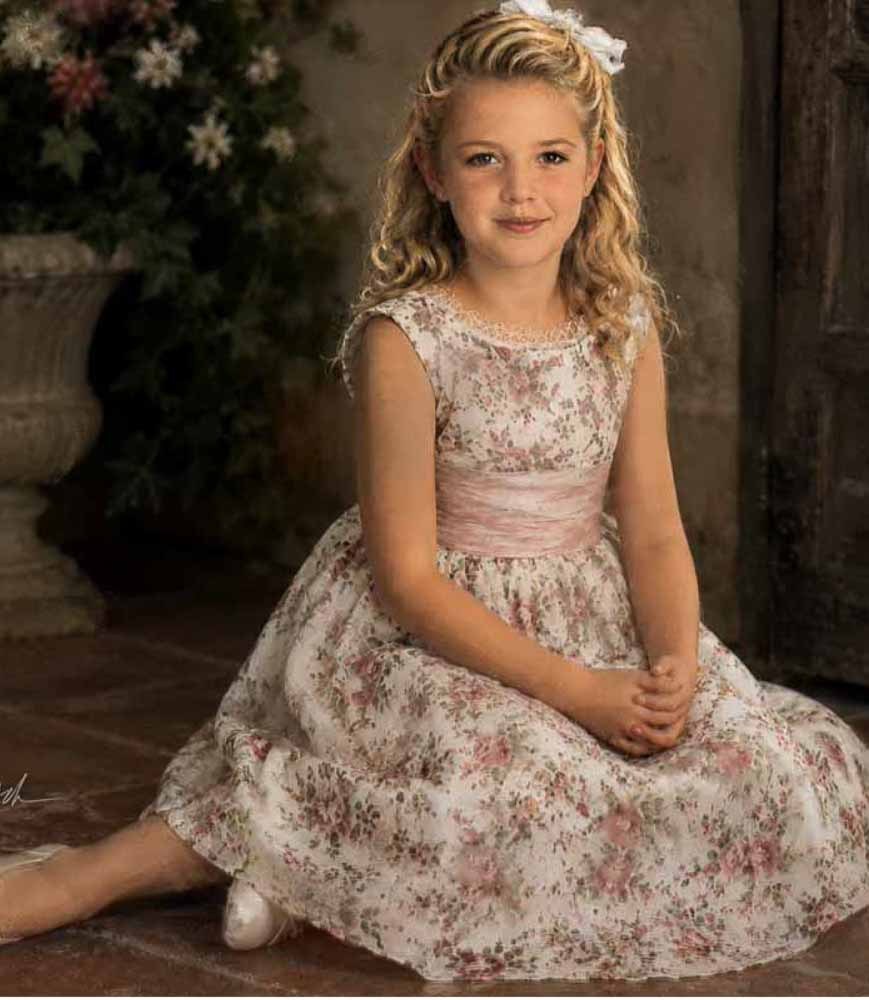Oil painting portrait of a young girl seated in a floral dress, rich and heirloom in feel.